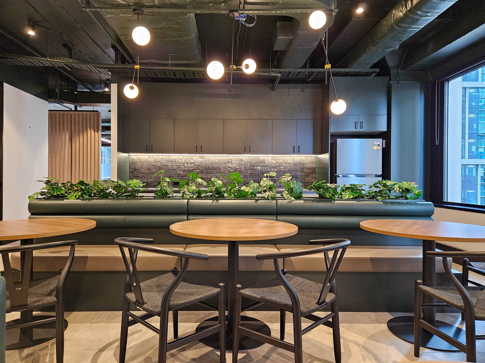 Office kitchen with tables, chairs, and plants