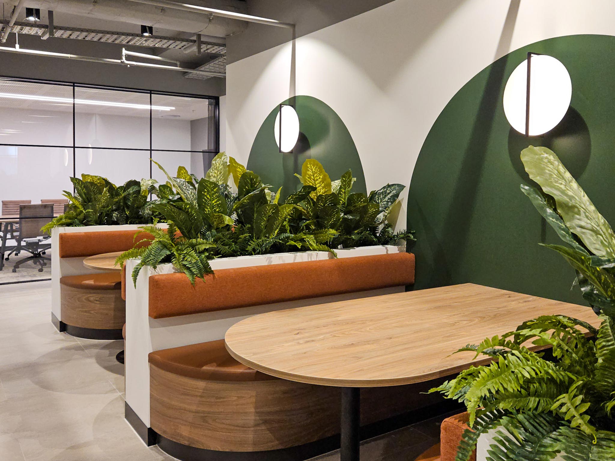 Custom booth seating in commercial office with green planters
